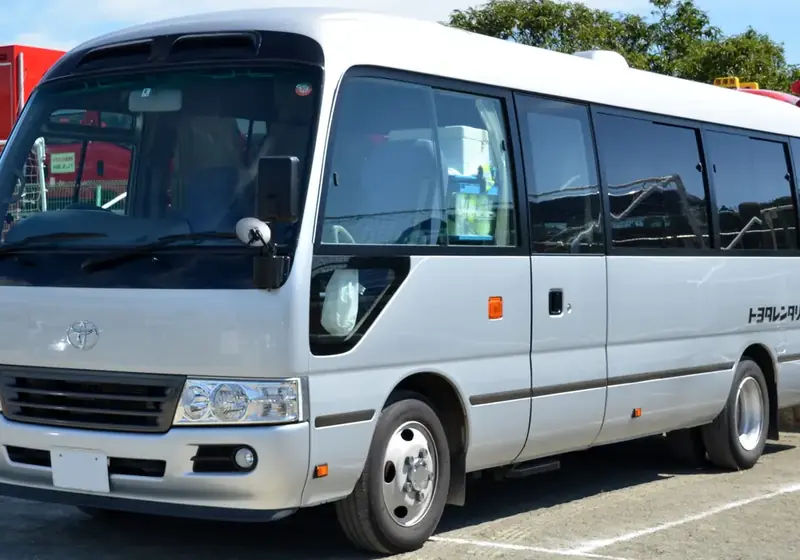 A coaster bus traveling on a scenic highway