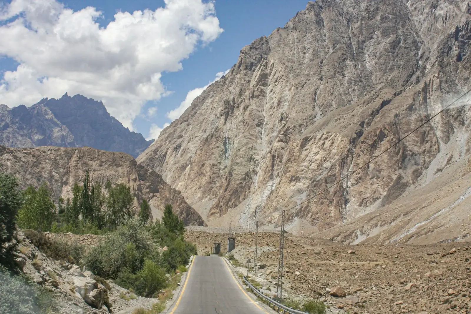 Rugged mountains in Hunza Nagar along a winding road under a clear blue sky