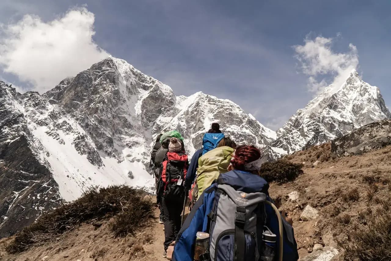 Group of hikers trekking with snow-capped mountains in the background