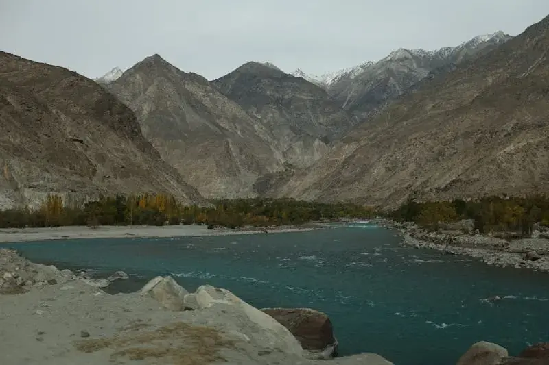 Captivating view of Gilgit's river with rocky mountains in vibrant colors