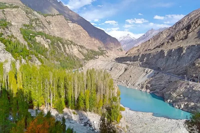 Turquoise river winding through a lush green valley surrounded by mountains