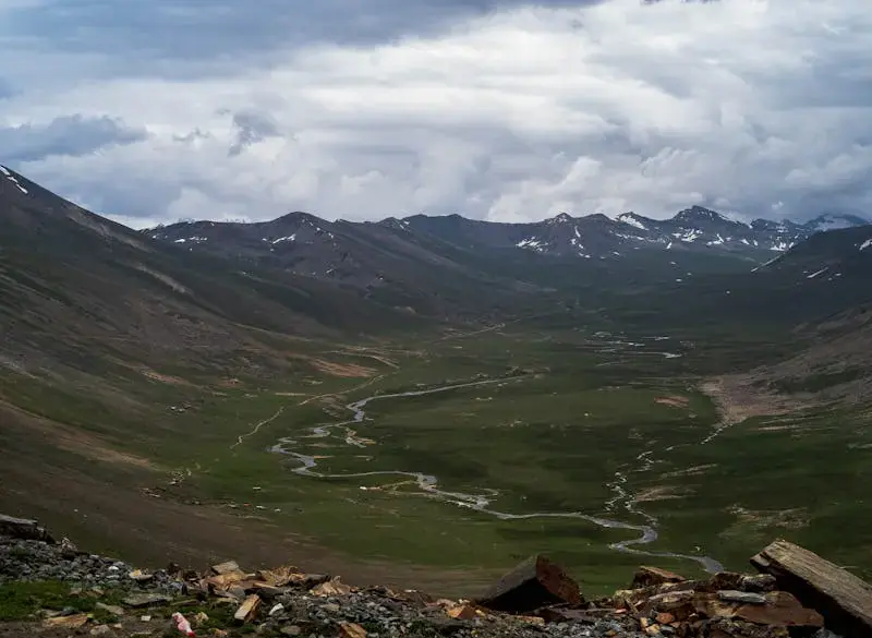 Serene valley landscape with a meandering river surrounded by majestic mountains